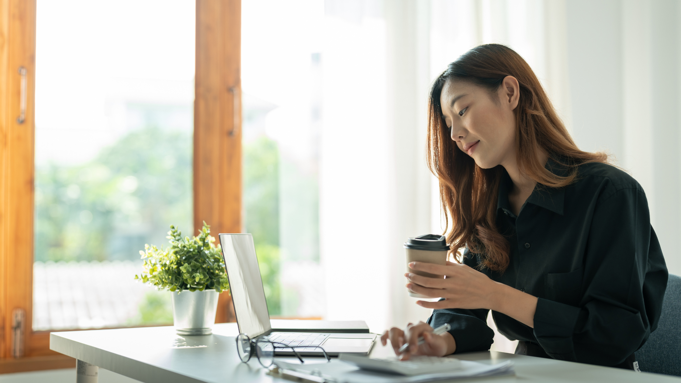 female at kitchen countertop working on laptop computer